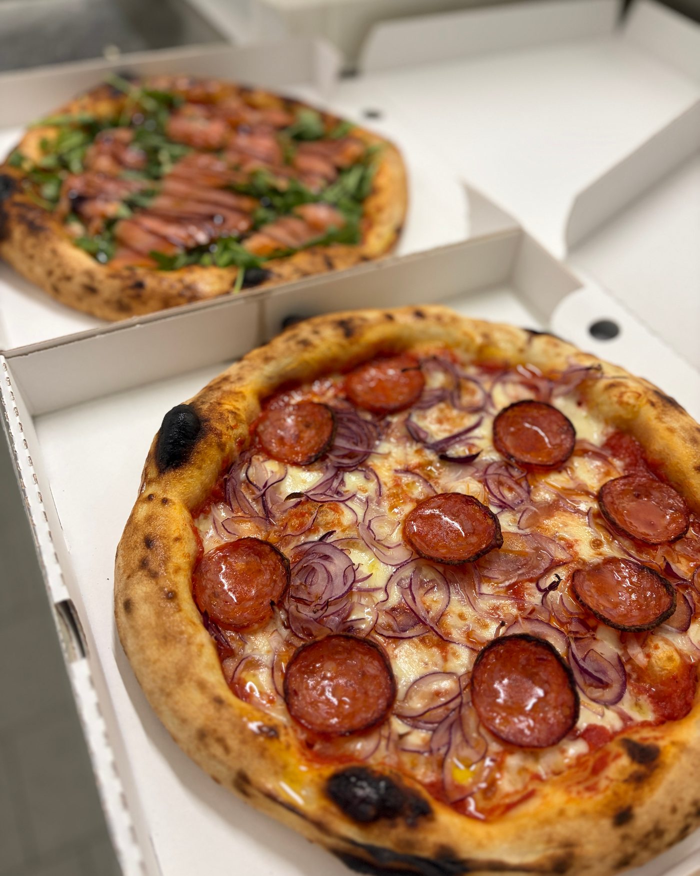 Mehrere Pizzen Salami in Kartons, bereit zum Mitnehmen
