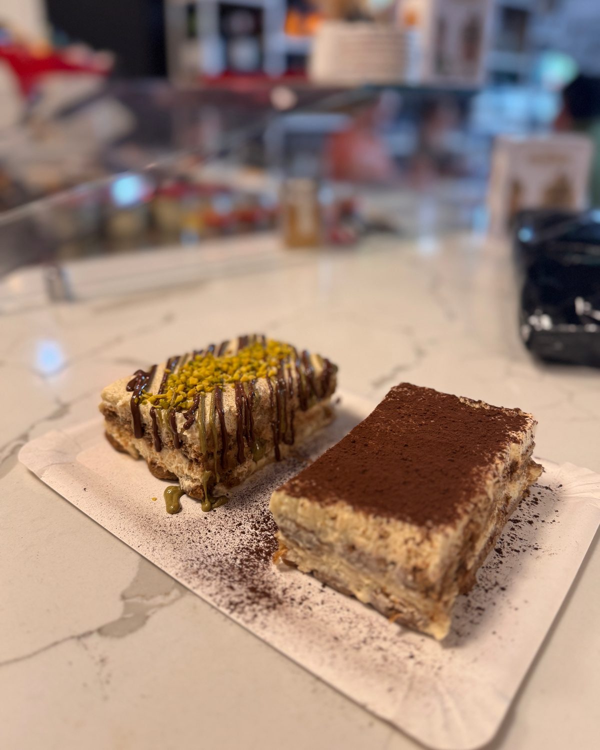 Tiramisu und Pistazienschnitte auf Marmor