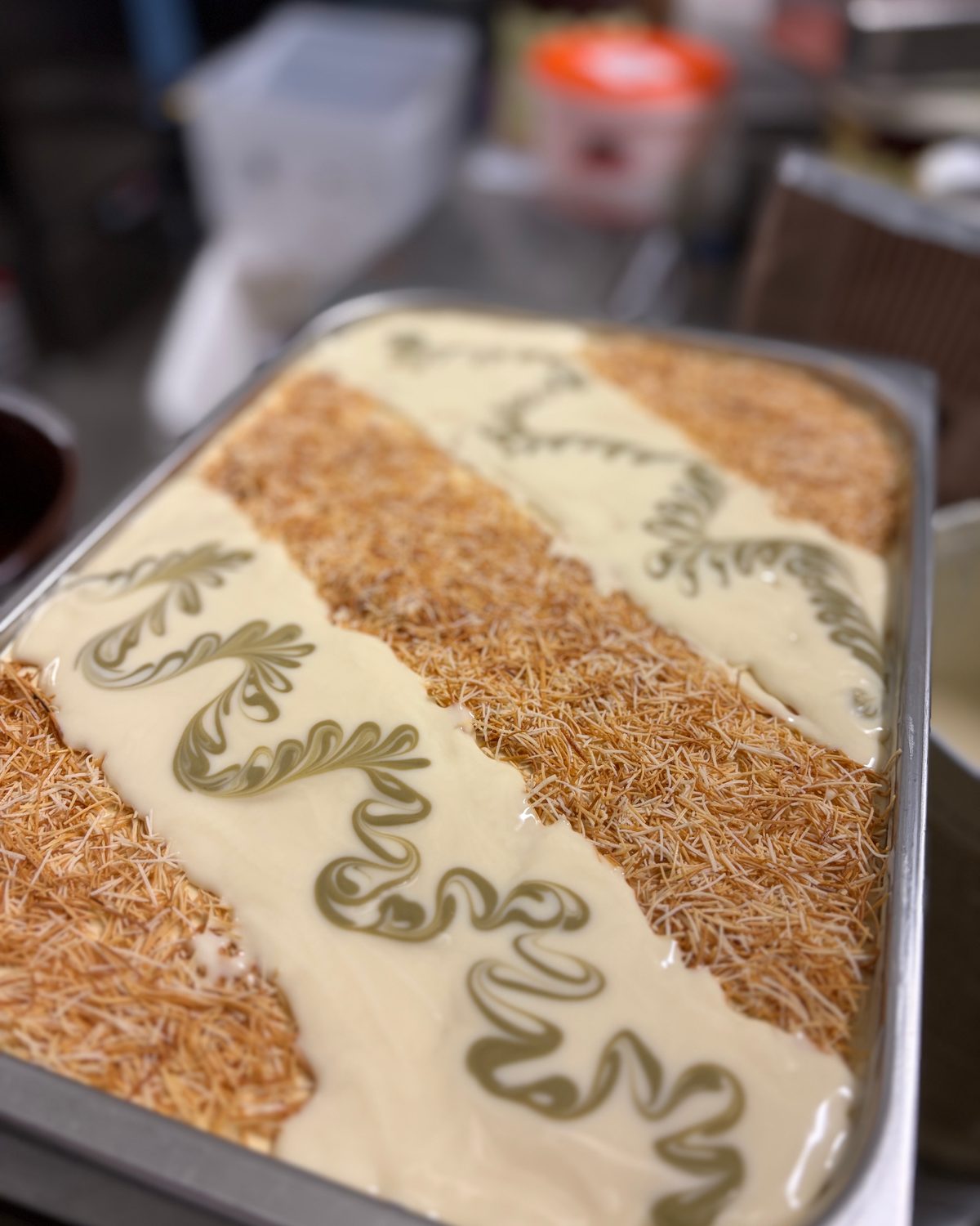 Eiswanne wird verziert: Streifen aus Krokant und Pistaziencreme-Ornamenten