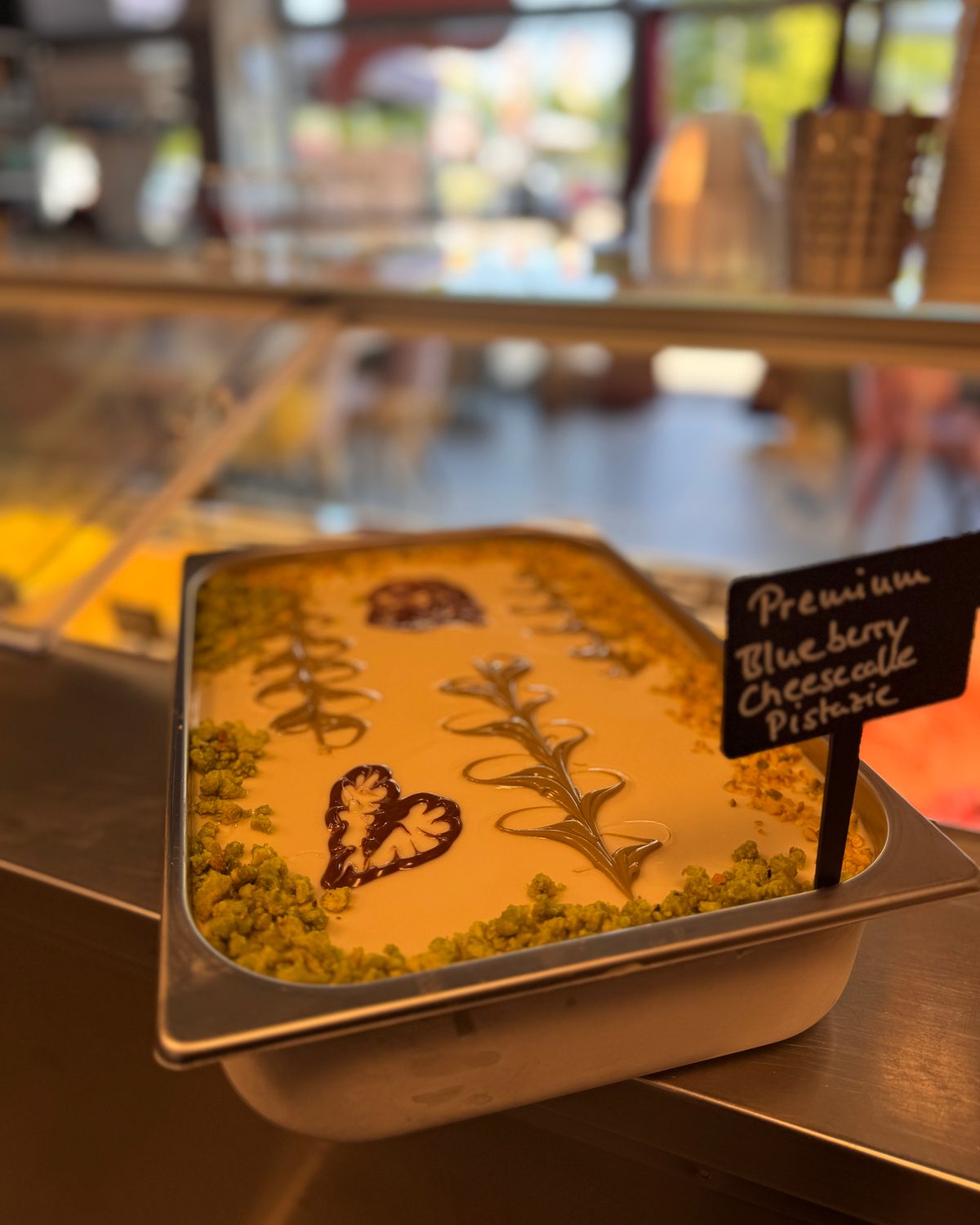 Wanne Premium Blueberry Cheesecake Pistazie mit Herz und Ranken aus Soße verziert