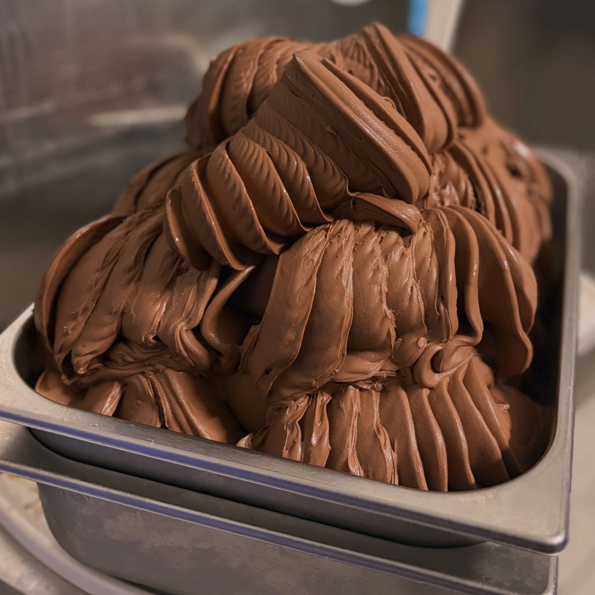 Schokoladen-Gelato frisch aus der Maschine, in Wellen aufgetürmt