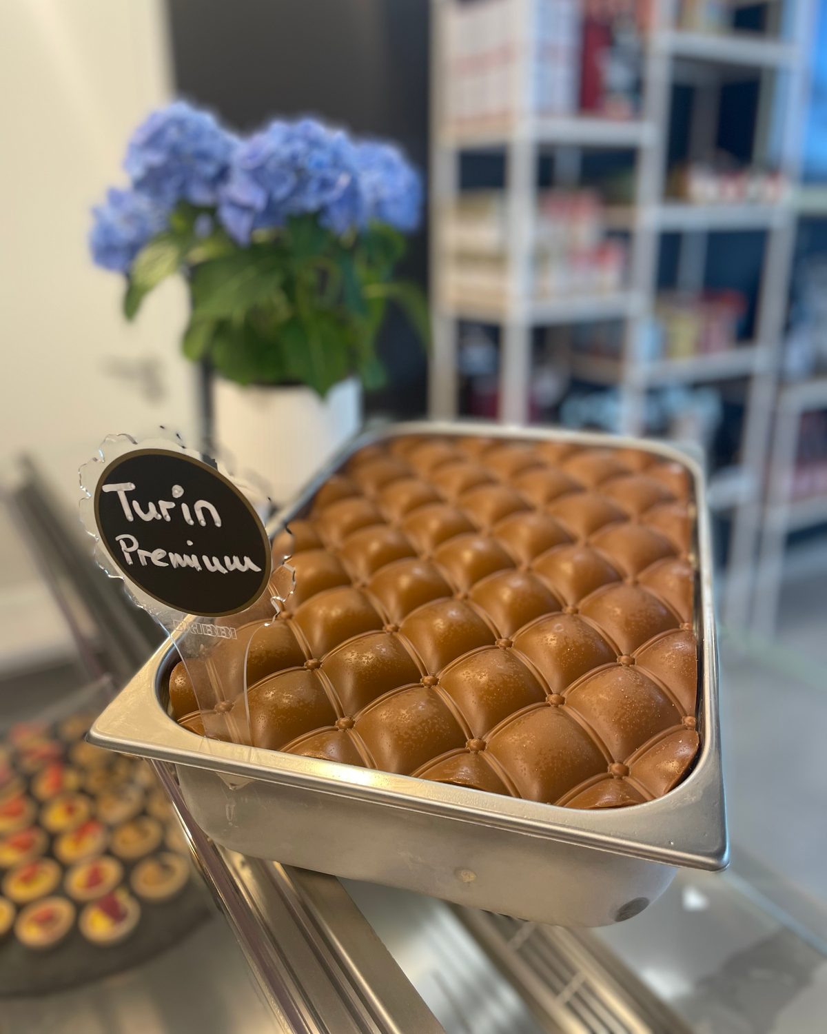 Wanne Turin Premium: Gelato mit Pralinen in Reihen, dahinter Hortensien