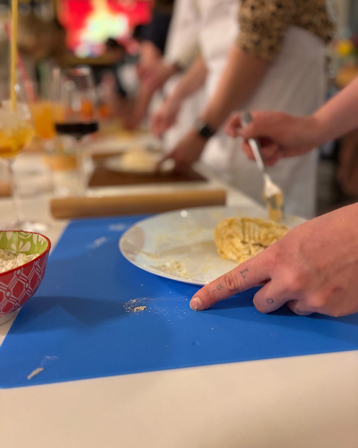 Pastakurs: Teilnehmer formen frischen Pastateig auf blauen Schneidebrettern