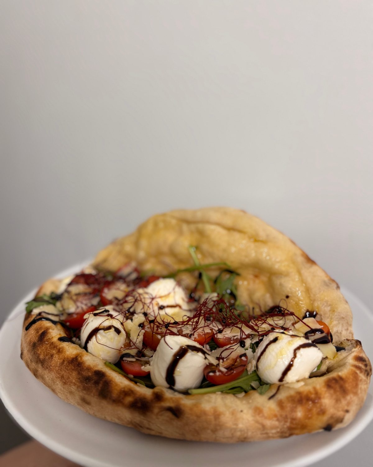 Gefüllte Teigtasche mit Mozzarellakugeln, Tomaten und Balsamico