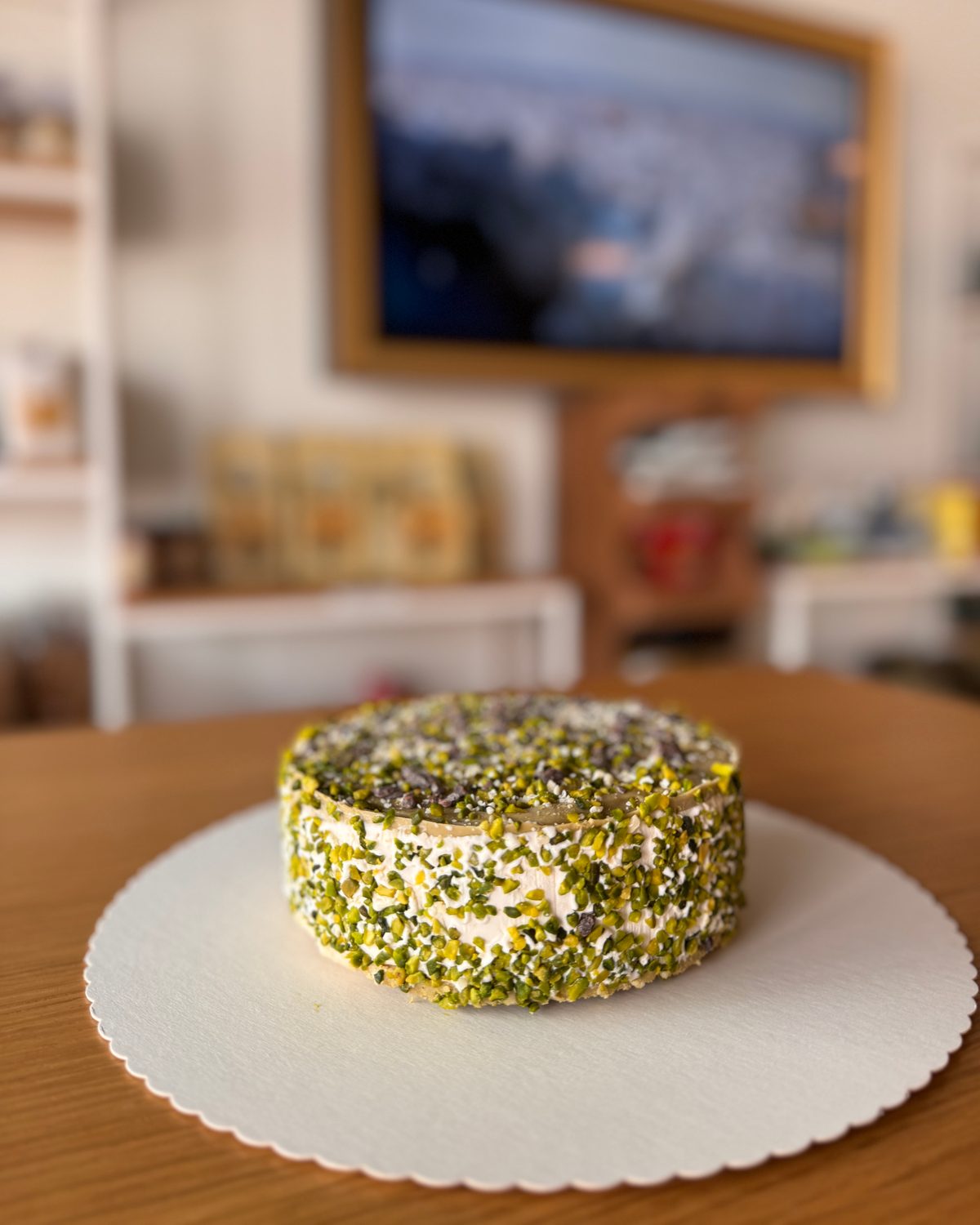 Kleine runde Torte, rundum mit gehackten Pistazien ummantelt